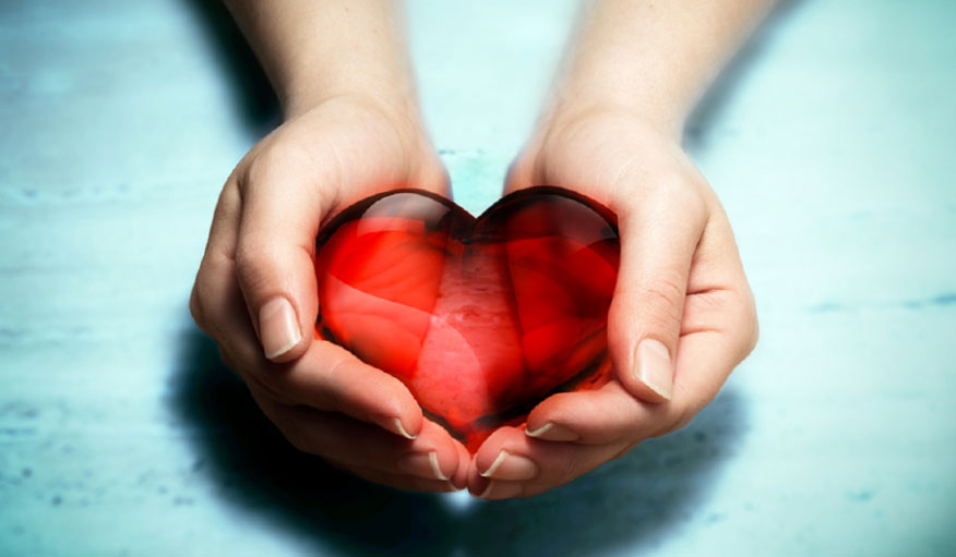 hands holding red glass heart